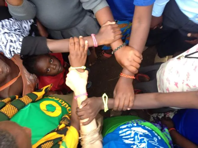 Linked arms symbolizing unity and support among diverse individuals.